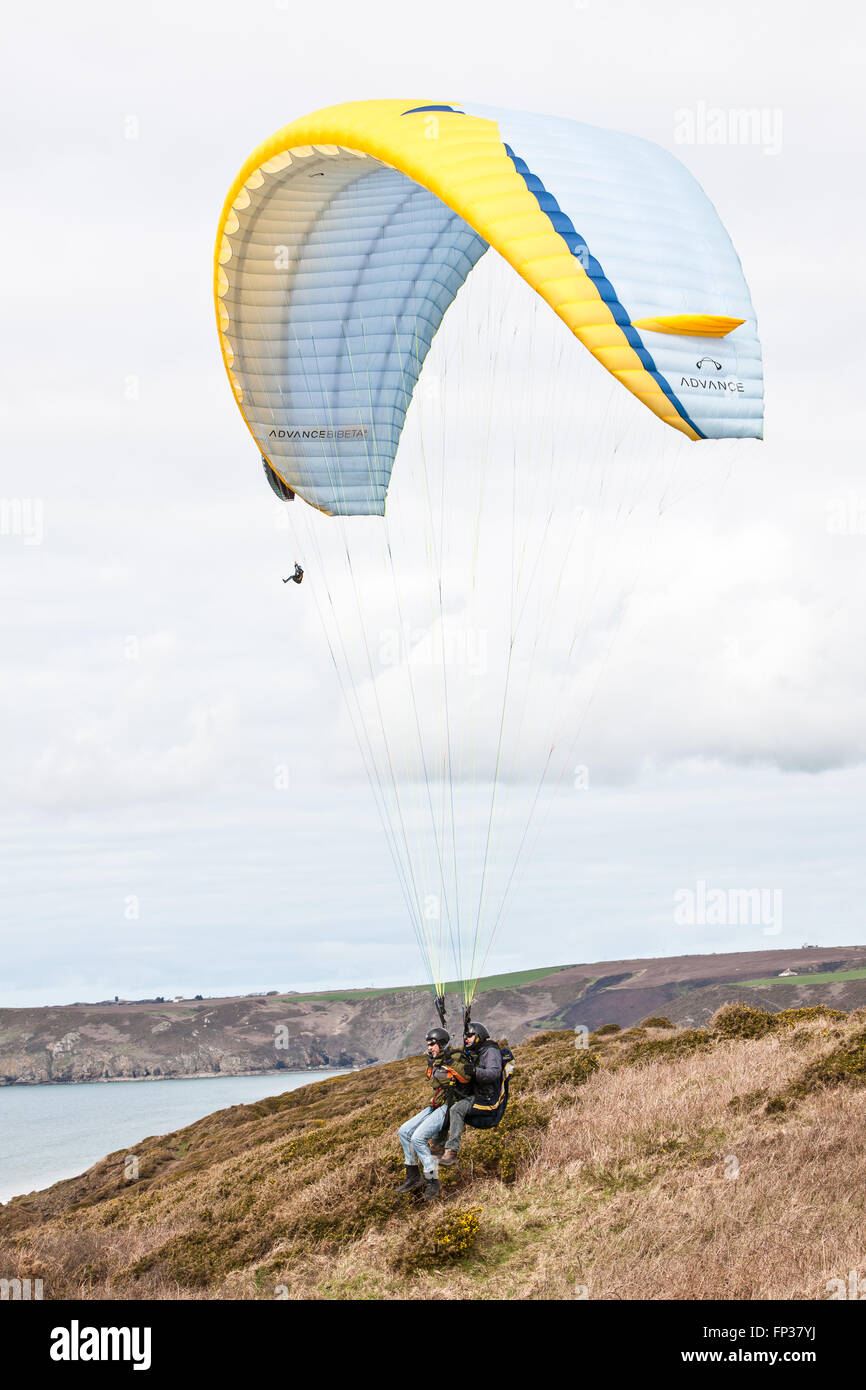 Il parapendio in tandem sopra la spiaggia Newgale lungo Il Pembrokeshire Coast Path vicino a St David's. West Wales, Galles,Welsh,U.K. L'Europa. Marzo. Foto Stock