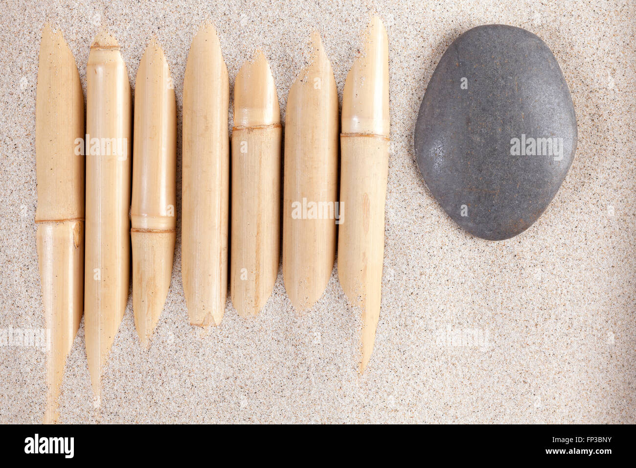Background fatti di bambù e pietre in sabbia, natura e concetto di armonia. Foto Stock