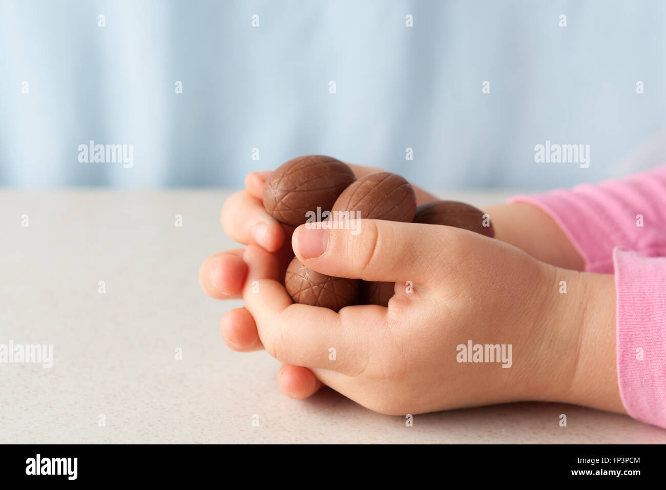 Bambino con le mani in mano tenendo le uova di Pasqua di cioccolata con coopy spazio. Vista laterale Foto Stock