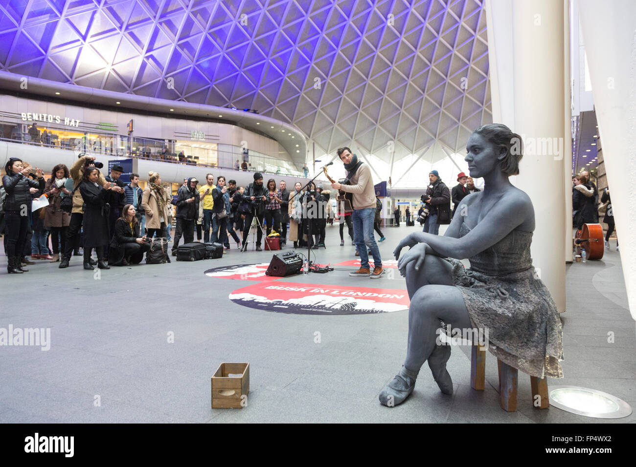 Londra, Regno Unito. Il 16 marzo 2016. Luca Fiore, vincitore del 2015 Busk a Londra la concorrenza, esegue sul piazzale della stazione di King Cross. Con Pippa Moss, statua vivente di una ballerina. Foto Stock
