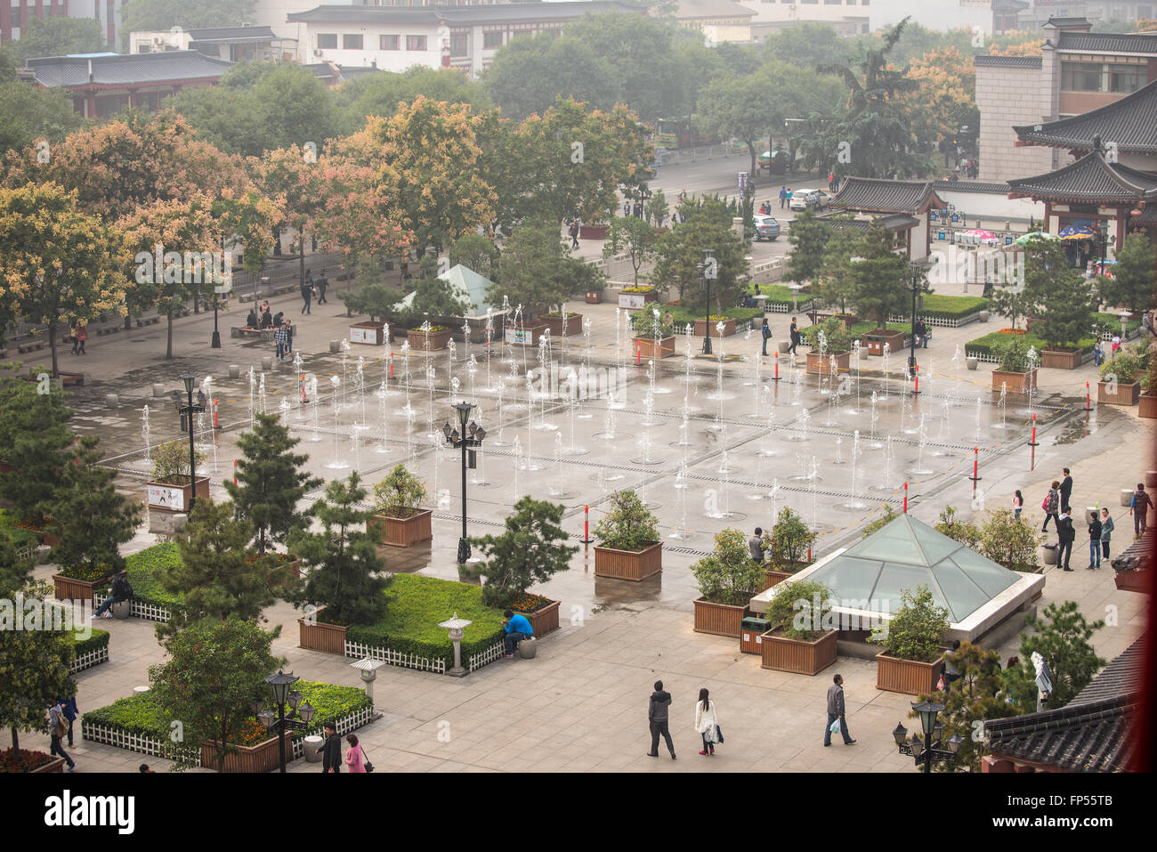 La popolazione locale e i turisti a piedi intorno alla fontana musicale nella piazza di Dayan pagoda, Xian, Cina Foto Stock