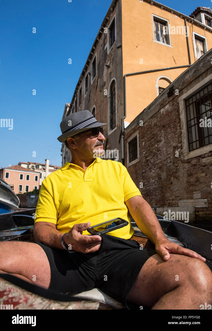 Tourist prende in luoghi su un rilassante giro in gondola di Venezia, Italia Foto Stock