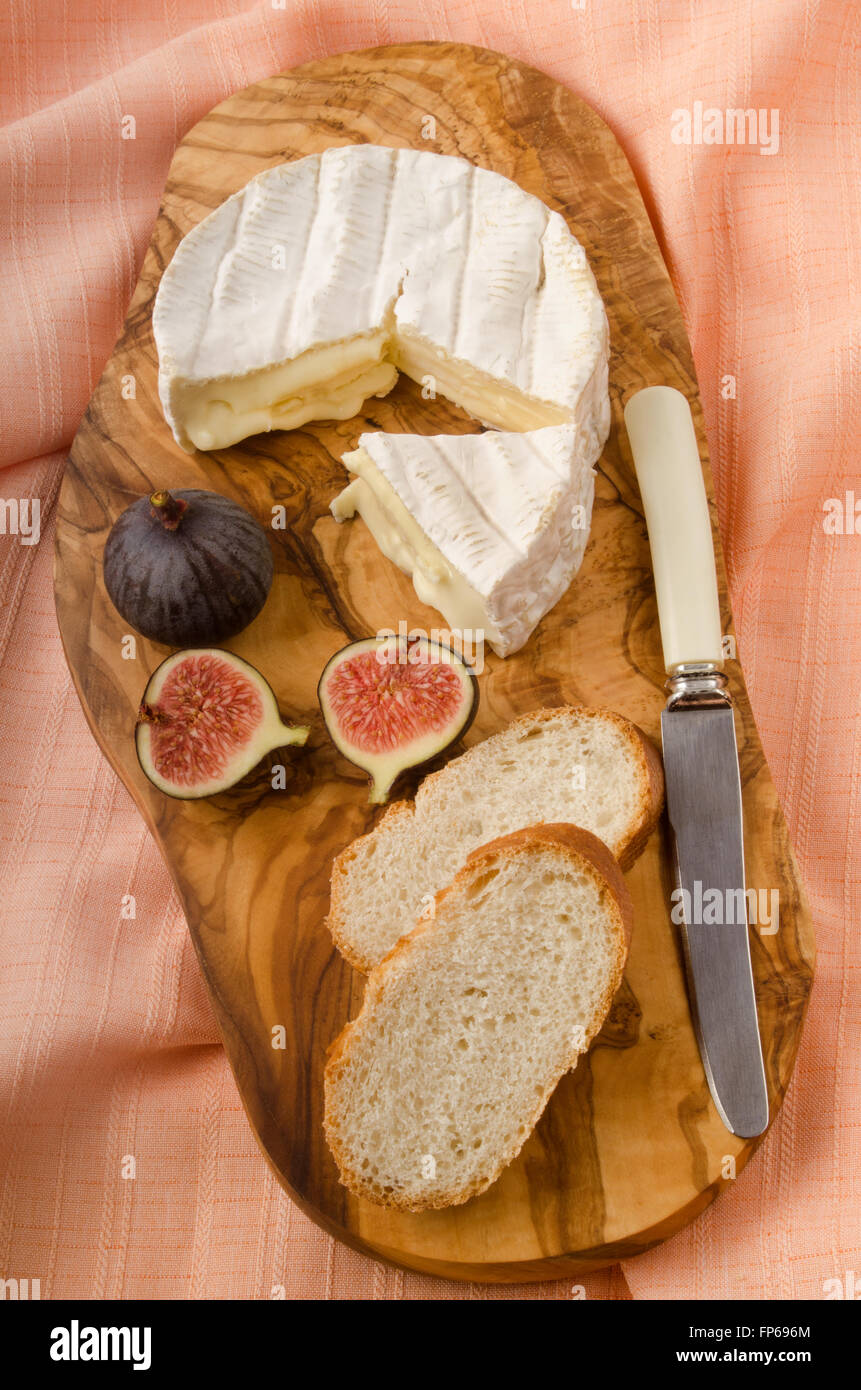 Camembert con fig, il pane e il coltello sulla tavola di legno Foto Stock