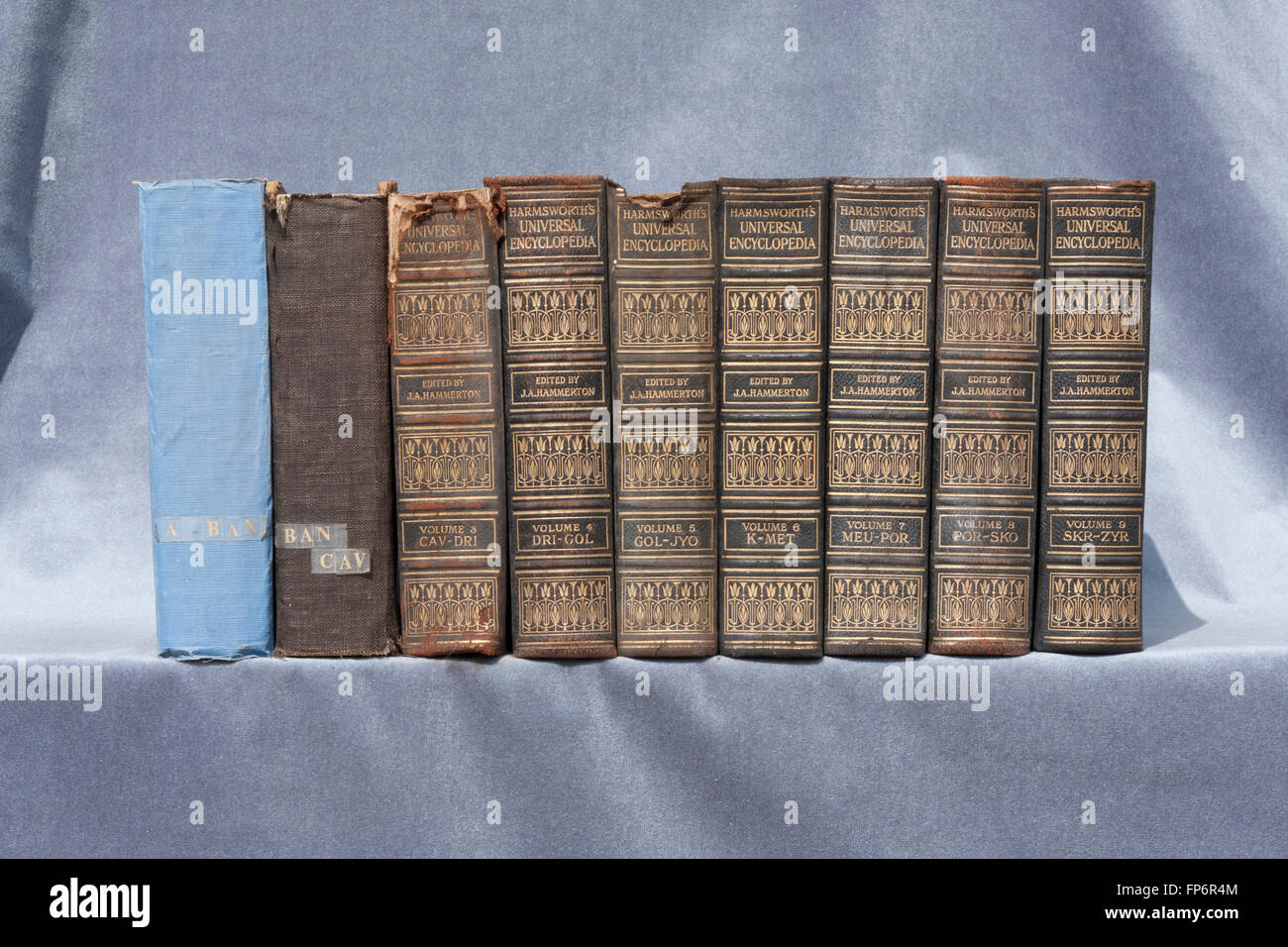 Una fila di vecchi libri sul velluto grigio sfondo Foto Stock