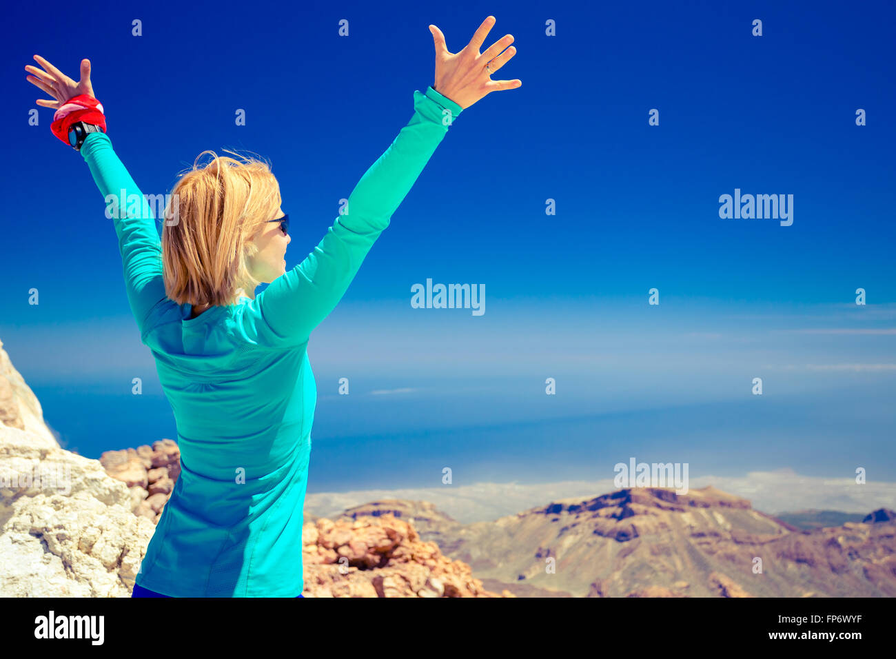 Donna di successo di arrampicata escursioni nelle montagne di ispirazione paesaggio, splendida vista oceano e. Escursionista femmina con le braccia in alto outst Foto Stock