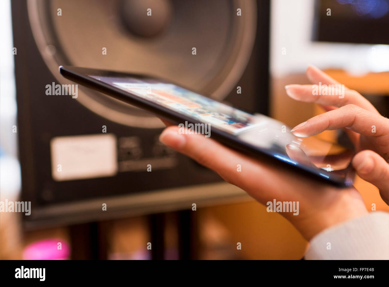 Donna in ascolto di musica da un app dispositivo tablet pc collegato. Contactless Foto Stock