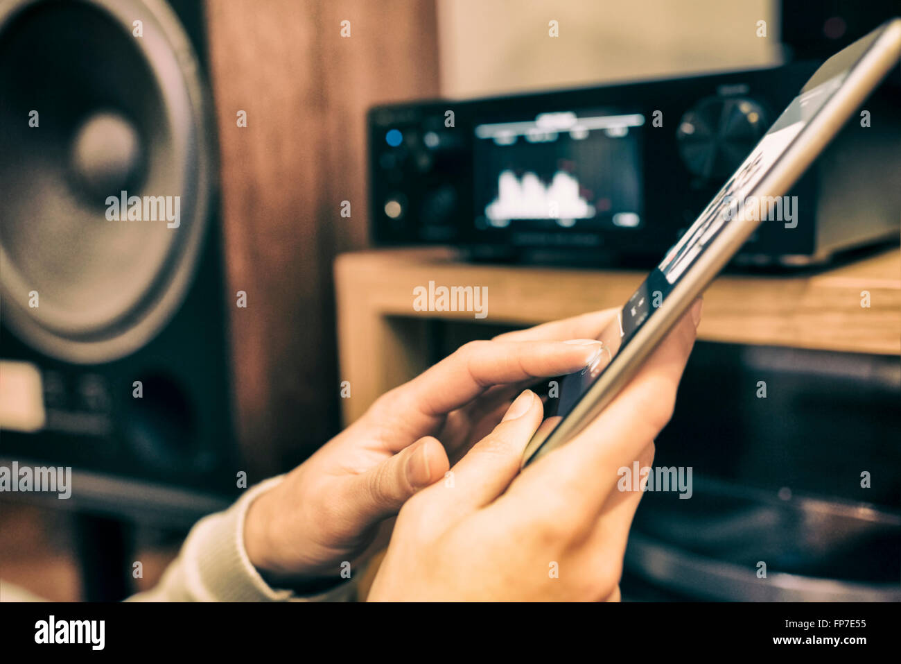 Donna app di ascolto di musica da un dispositivo tablet pc collegato. Contactless. Il filtro vintage Foto Stock
