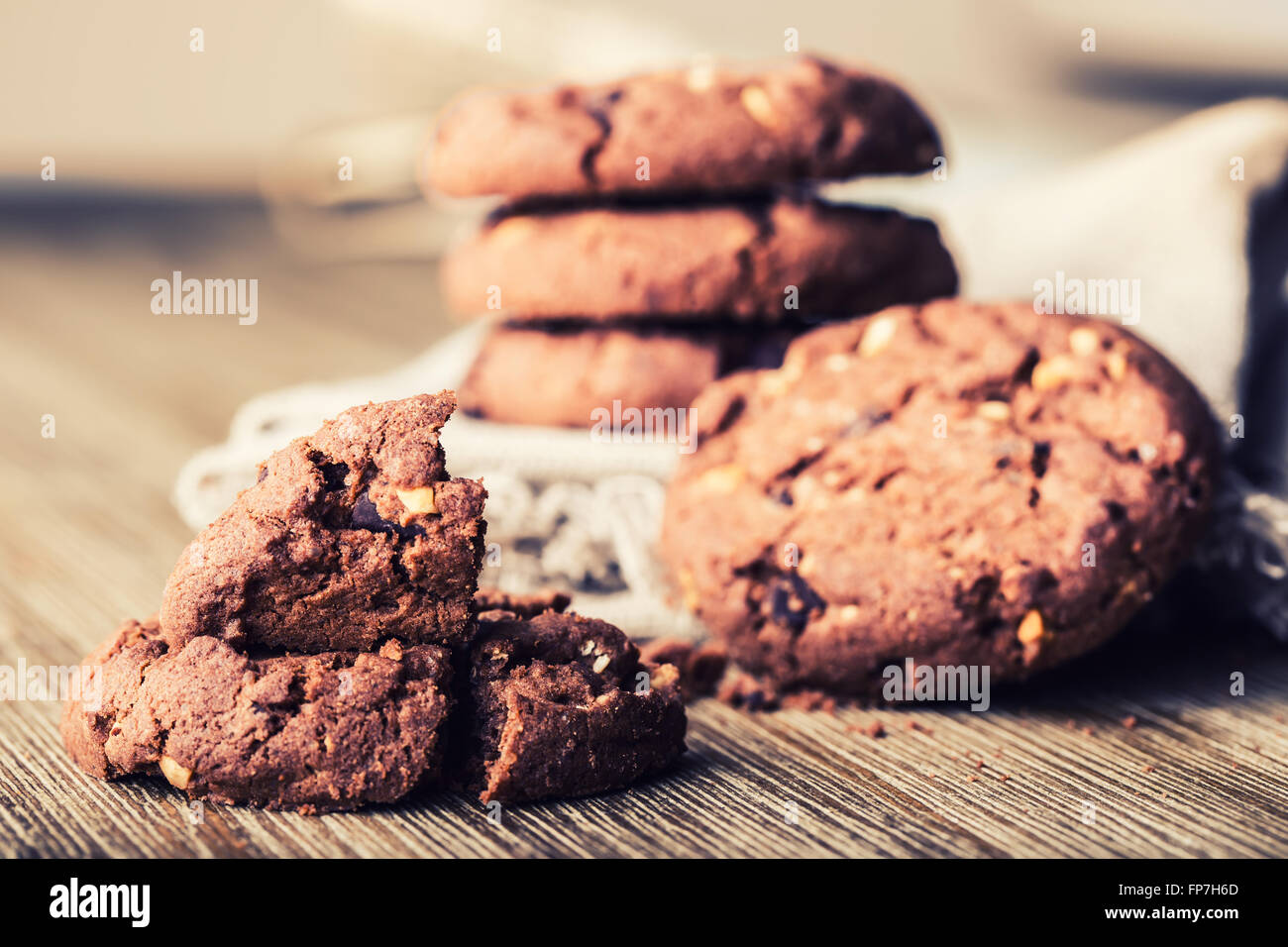 Biscotti al cioccolato i cookies. Biscotti al cioccolato sulla biancheria da letto bianca igienico sul tavolo di legno. Foto Stock