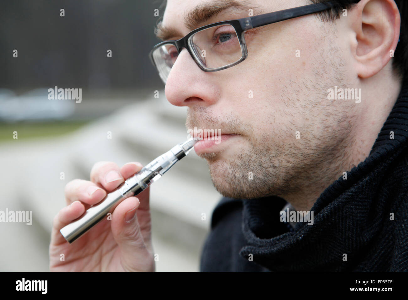 Giovane uomo di fumare un e-sigaretta Foto Stock