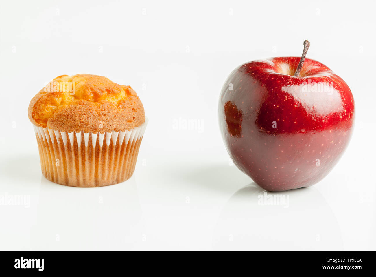Muffin o una bella sana rosso lucido apple una dieta o junk food concept Foto Stock