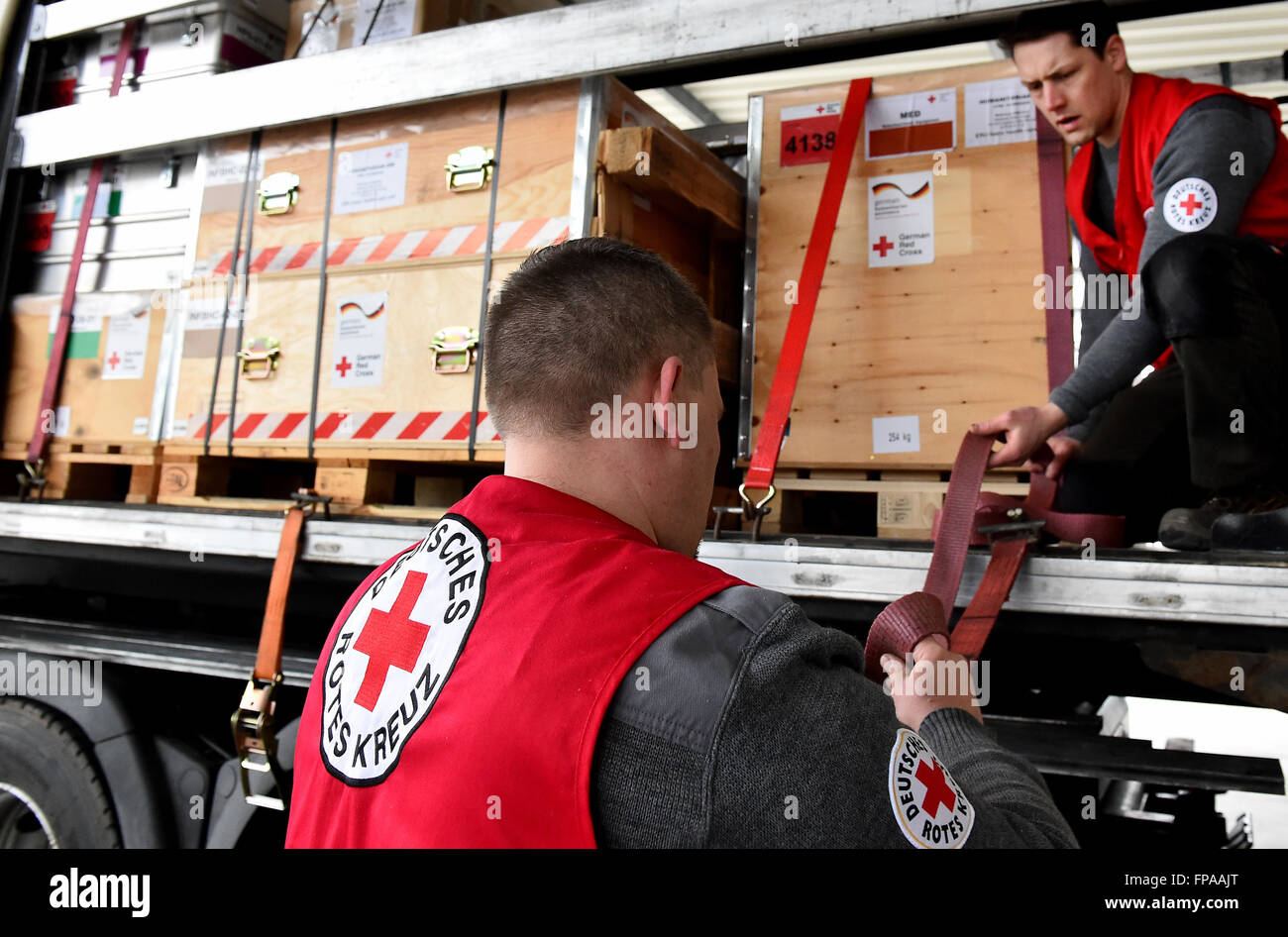 I membri dello staff della Croce Rossa tedesca (DRK) fissano la paura di un carrello che trasporta di forniture di soccorso in Schoenefeld, Germania, 18 marzo 2016. La DRK invia un medico di base station per fornire aiuto medico per circa diecimila persone per la regione intorno a Idomeni nella Grecia settentrionale. Foto: Bernd Settnik/dpa Foto Stock