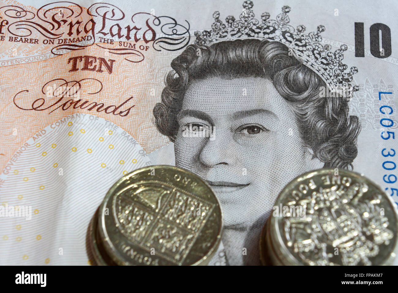 British 10 pound nota e la pila di £ 1 monete Foto Stock