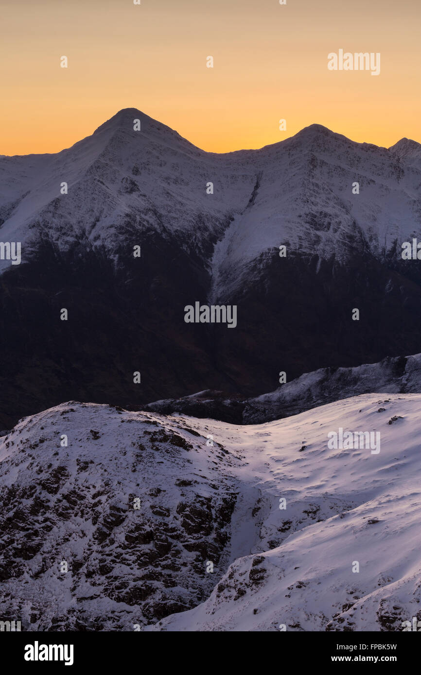 Due delle cinque Sorelle di Kintail (Sgurr Fhuaran e Sgurr na Carnach) si trasformano in alba, da Sgurr Mhic Bharraich durante l'inverno Foto Stock