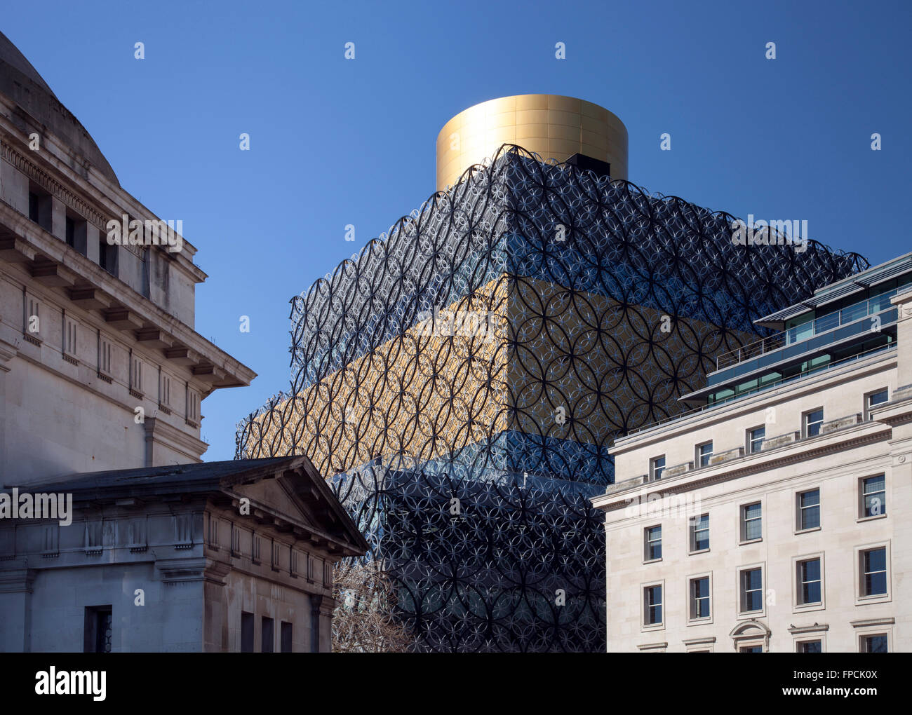 Visto da una distanza, ai piani superiori della Biblioteca di Birmingham, con le pareti che sembrano essere coperti in mesh, e una fascia in oro separare due pannelli più scura e un imbuto come struttura sul tetto progettato da Mecanoo architects. Foto Stock