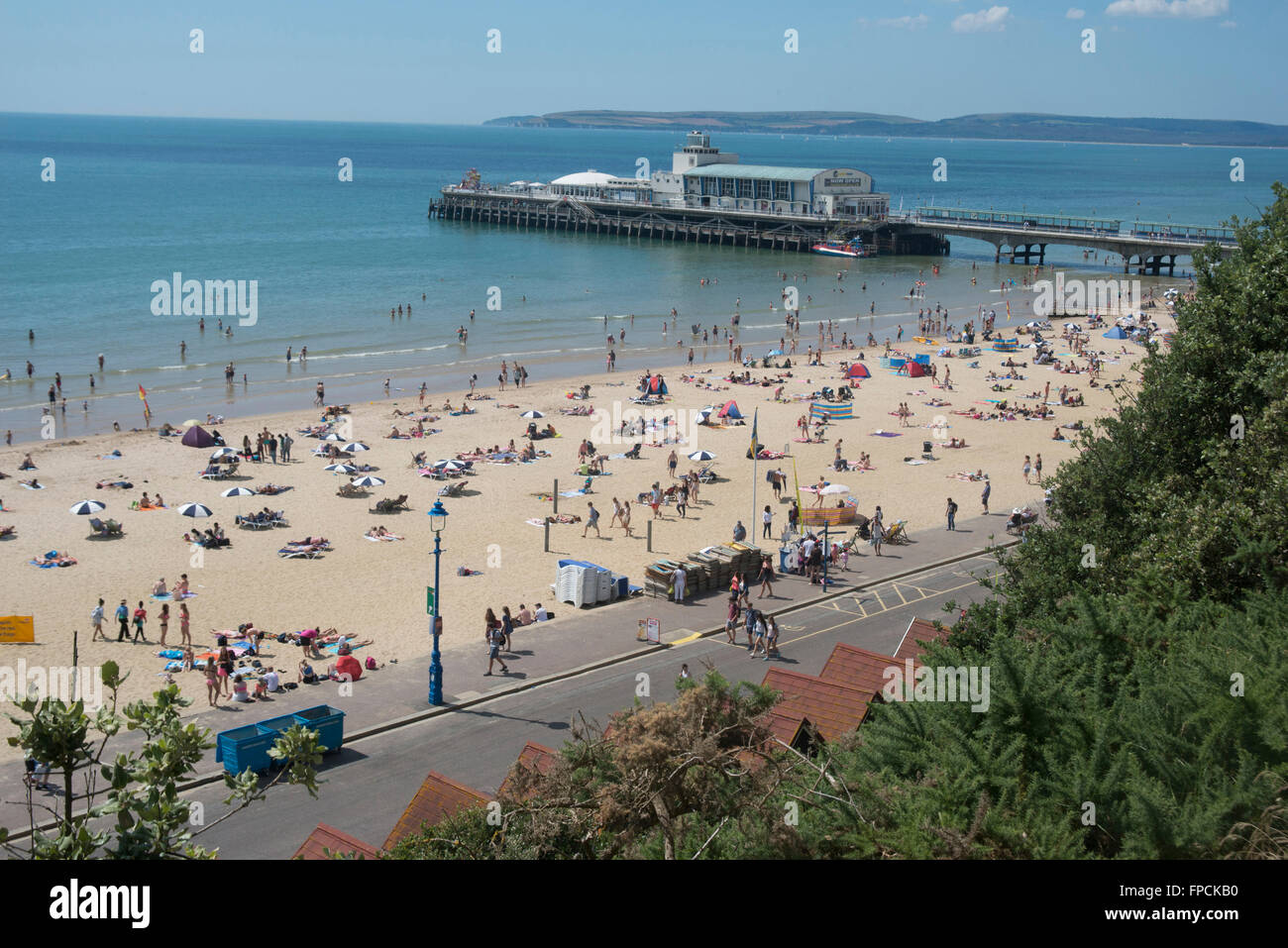 Una vista da sopra della spiaggia piena di gente, il molo può essere visto in lontananza. Foto Stock