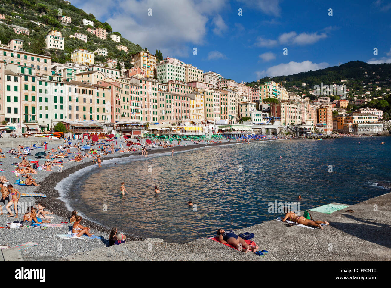 Una folla di gente che godendo una giornata fuori a Camogli beach resort sulla costa ligure. Foto Stock