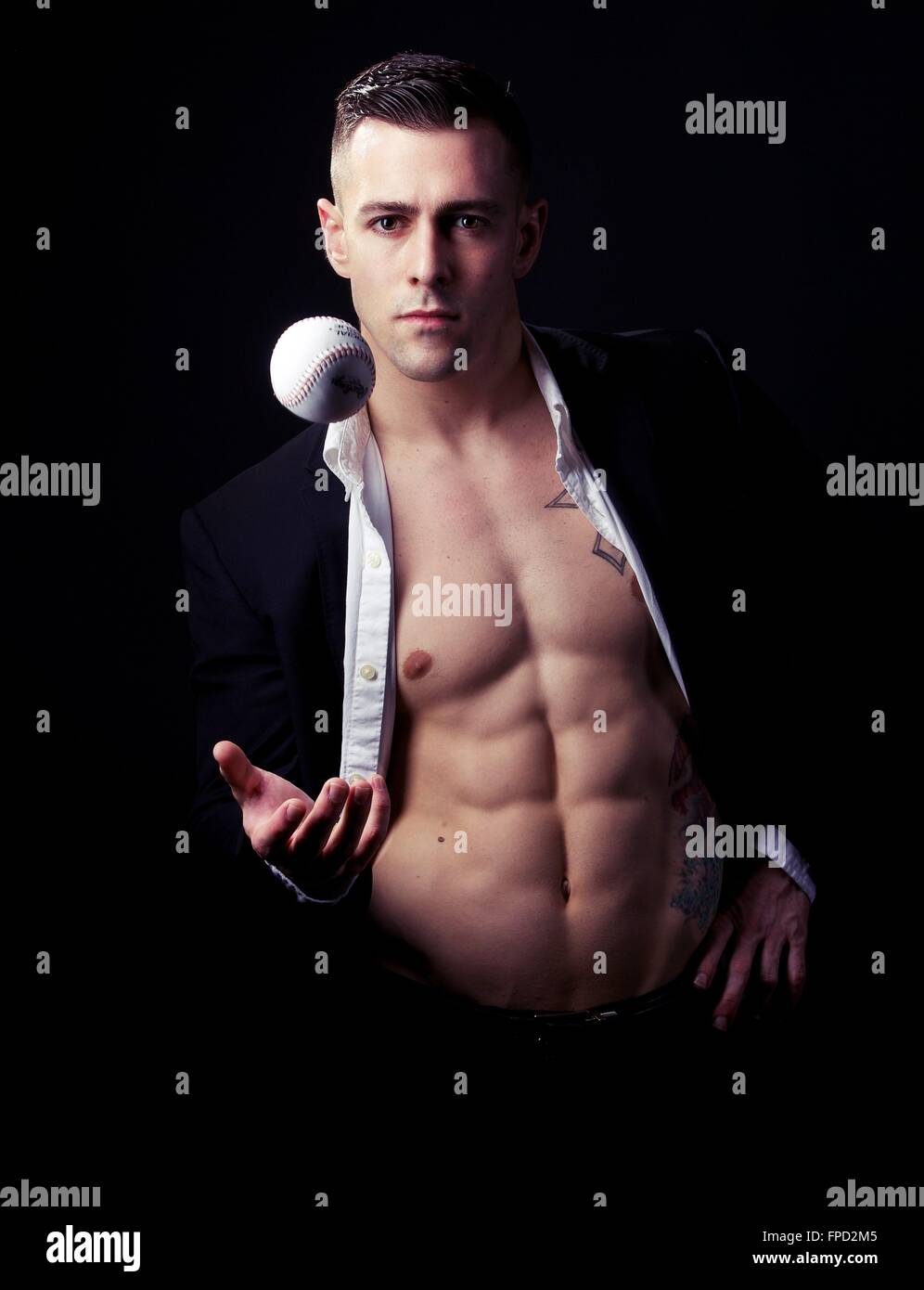 Uomo con petto mostra gettando un baseball Foto Stock