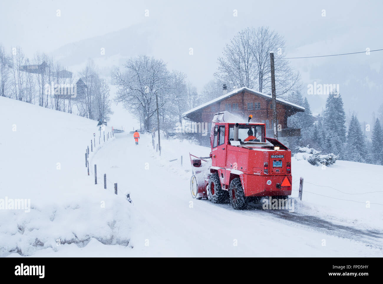 Un sgombero neve macchina lo sgombero neve nel villaggio alpino di Lenk, il Cantone di Berna, alpi svizzere, Svizzera, Europa Foto Stock