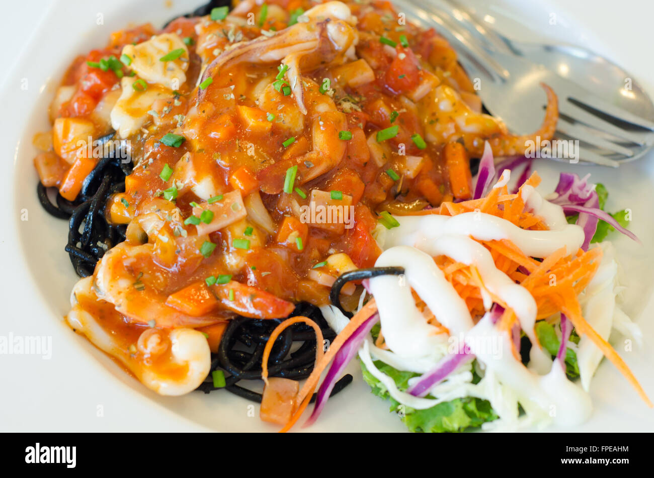Gli spaghetti al nero di frutti di mare sulla piastra bianca Foto Stock