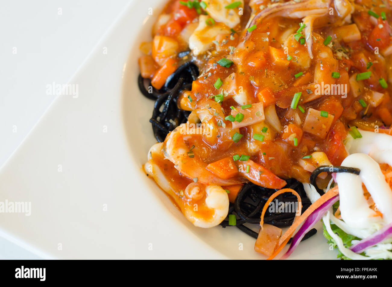 Gli spaghetti al nero di frutti di mare sulla piastra bianca Foto Stock