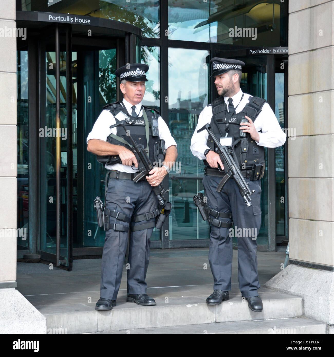 Regno Unito armati di polizia Metropolitan Police officer azienda armi visibili sul dovere all'entrata Portcullis House Casa del Parlamento Londra Inghilterra REGNO UNITO Foto Stock