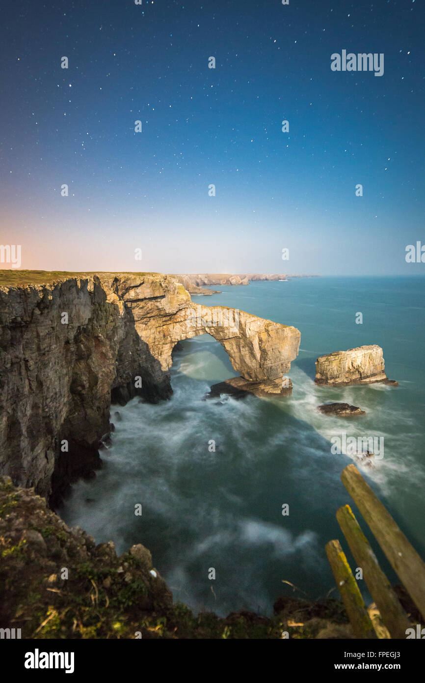 Un vicino alla luna piena illumina il Ponte Verde del Galles e il South Pembrokeshire litorale Foto Stock