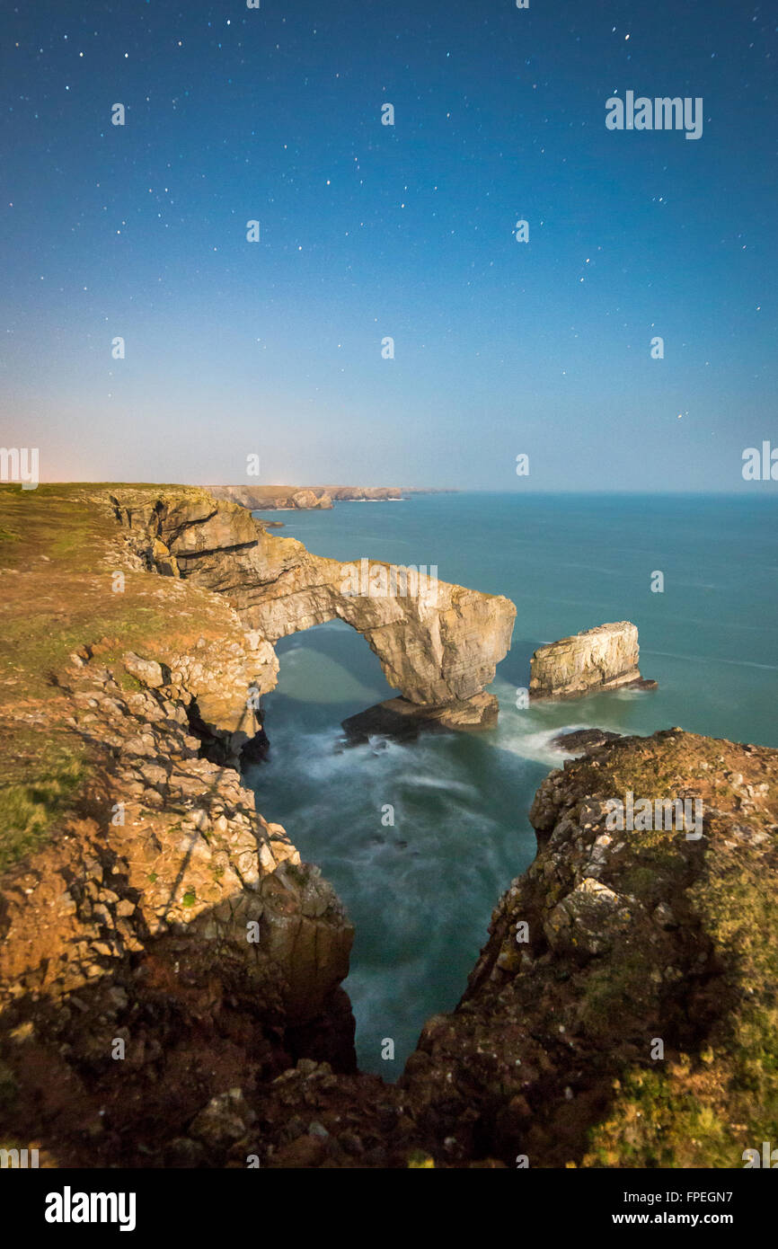 Un vicino alla luna piena illumina il Ponte Verde del Galles e il South Pembrokeshire litorale Foto Stock