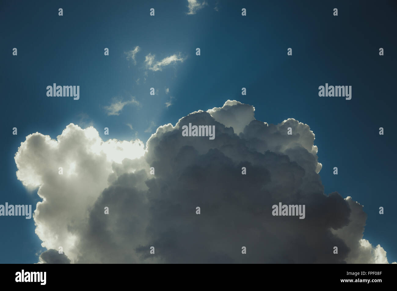 Raggi di sole che splende attraverso cumulonimbus nuvole, immagine tonificante Foto Stock