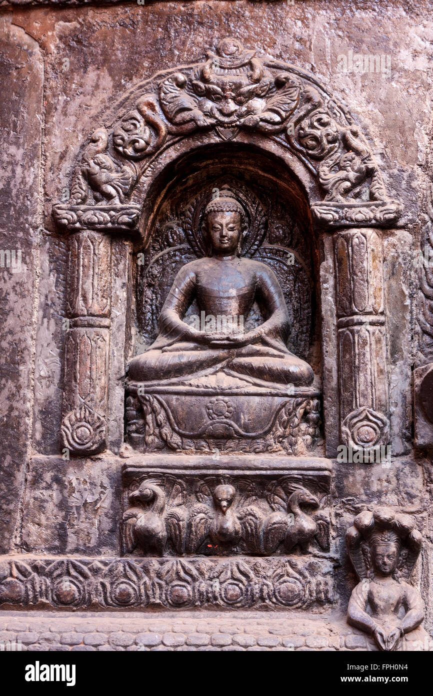 Il Nepal, Patan. Buddha nella Dhyana Mudra posizione, che simboleggiano la meditazione. Ingresso per il buddista Tempio d'Oro (Kwa Baha). Foto Stock