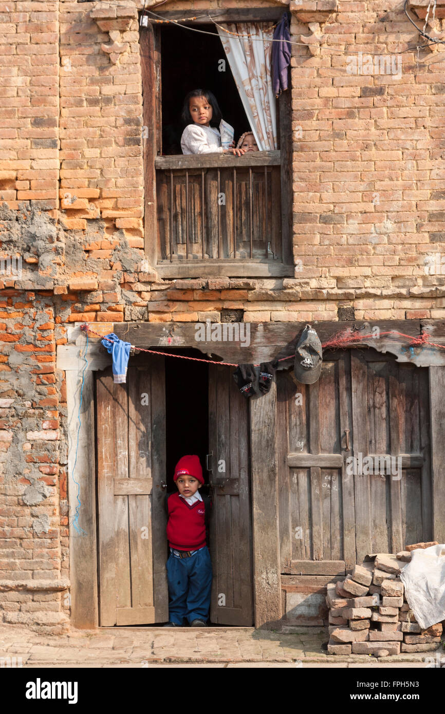 Il Nepal, Patan. Ragazza in finestra, Boy in porta. Foto Stock