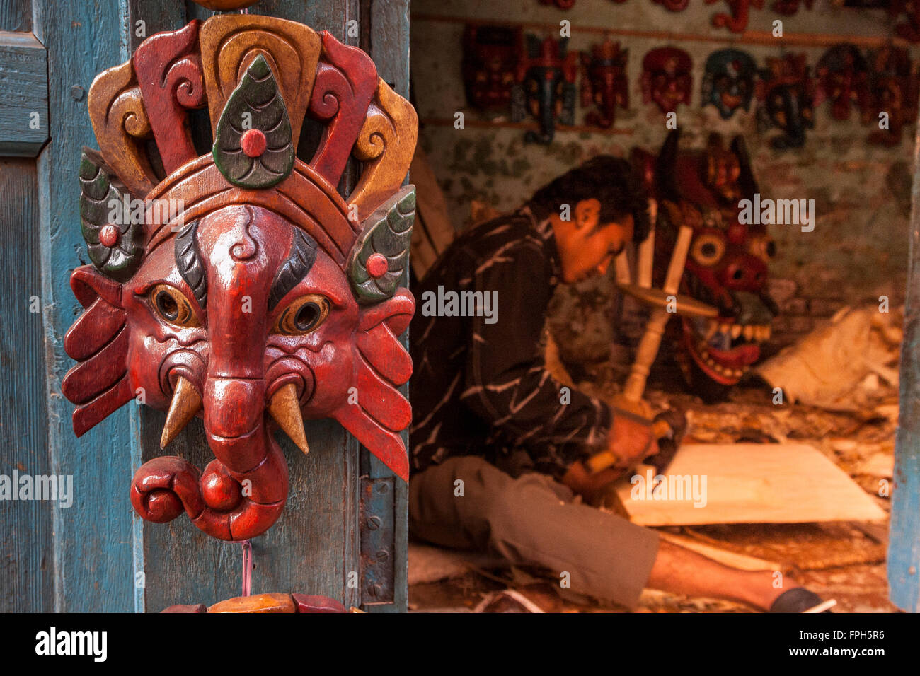 Il Nepal, Patan. Ganesh maschera su porta a maschera-carver della bottega. Foto Stock