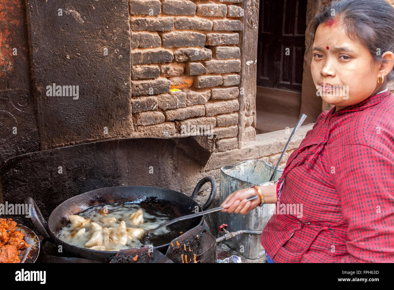 Il Nepal, Patan. Cibo di strada frittura fornitore Mo-mo gnocchi. Foto Stock