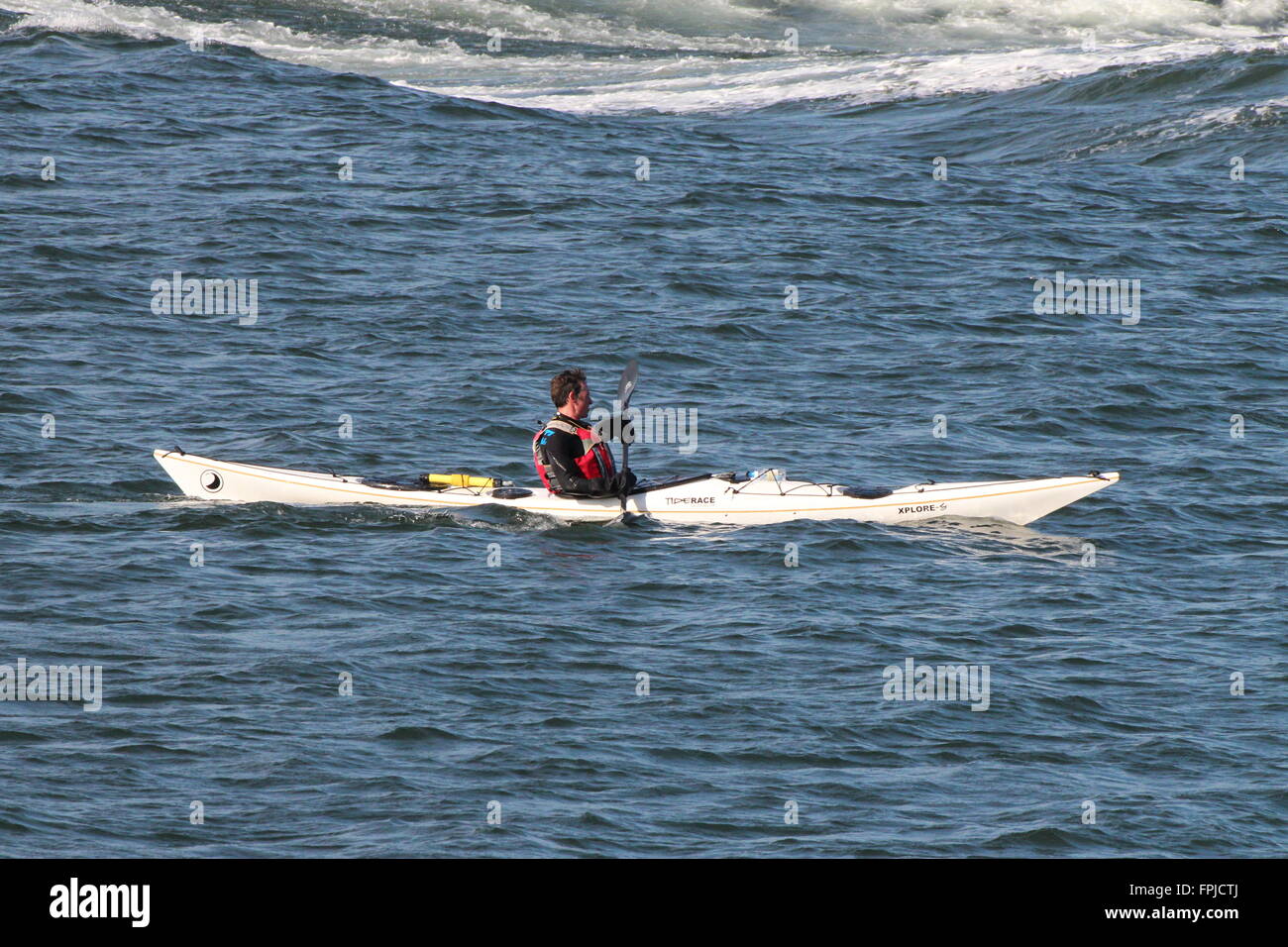 Un mare kayaker, utilizzando un Tiderace Xplore-S accoppiato con Werner pagaie, off Gourock in Inverclyde. Foto Stock