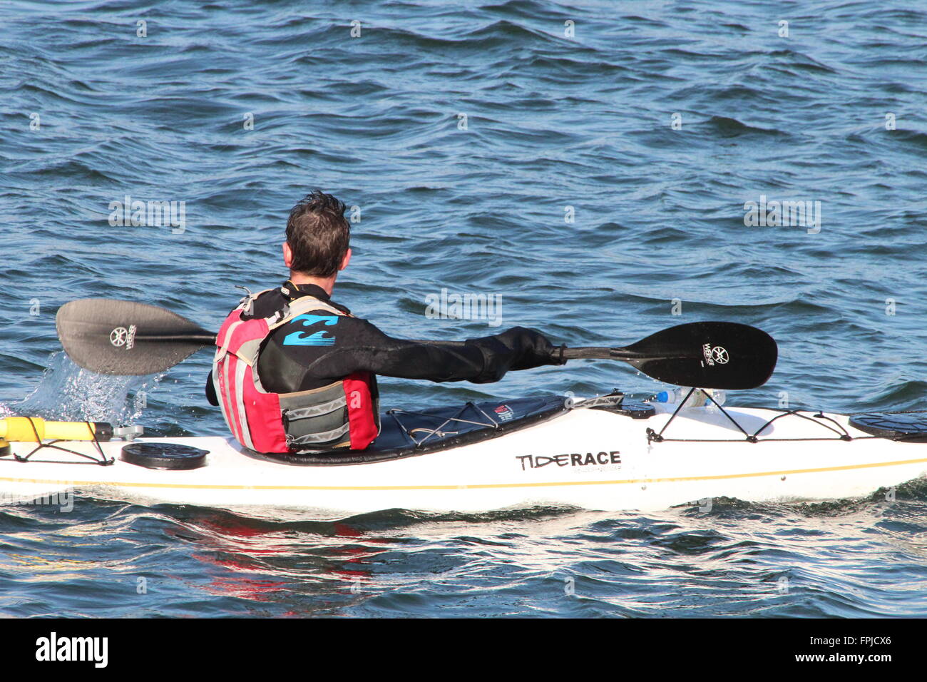 Un mare kayaker, utilizzando un Tiderace Xplore-S accoppiato con Werner pagaie, off Gourock in Inverclyde. Foto Stock