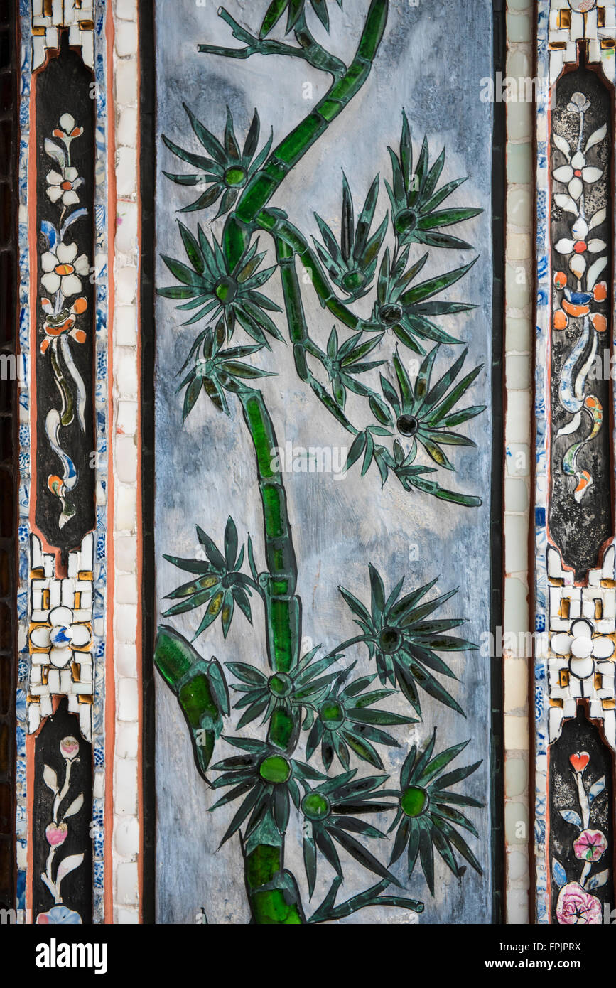 Vetro e ceramica di foglie di palma mosaici decorare le colonne dei palazzi della città IOmperial o Citdel, tonalità, Vietnam. Foto Stock