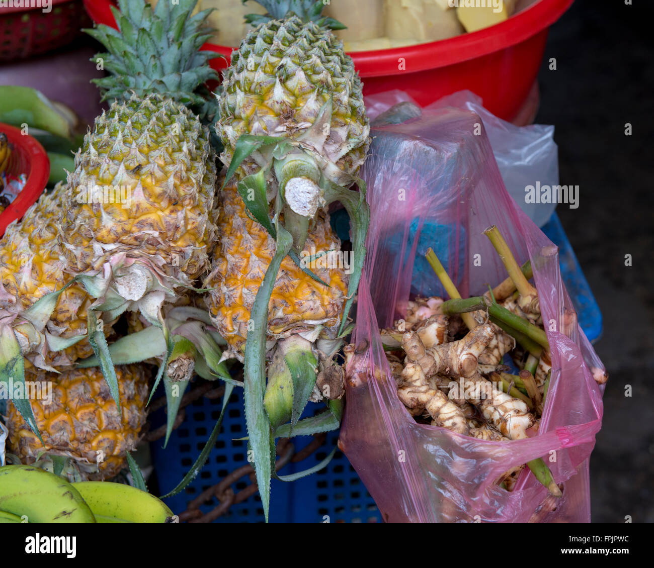 Piccolo ananas, banane e galangal fresche in vendita in Hoi An mercato, Vietnam Foto Stock