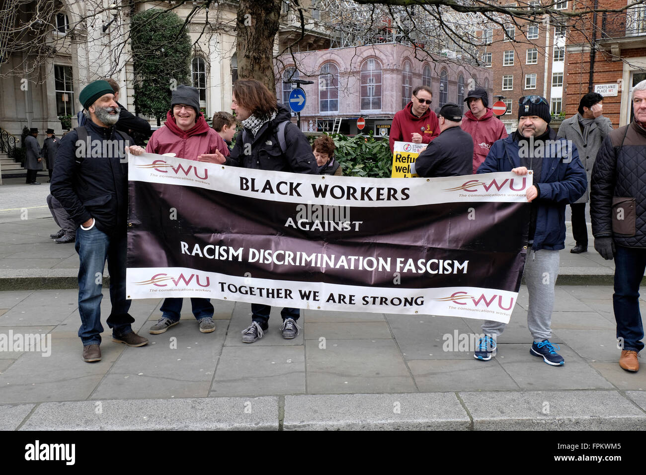 Due uomini asiatici tenere un banner di lettura "in nero dei lavoratori contro il razzismo, la discriminazione, il fascismo' Foto Stock