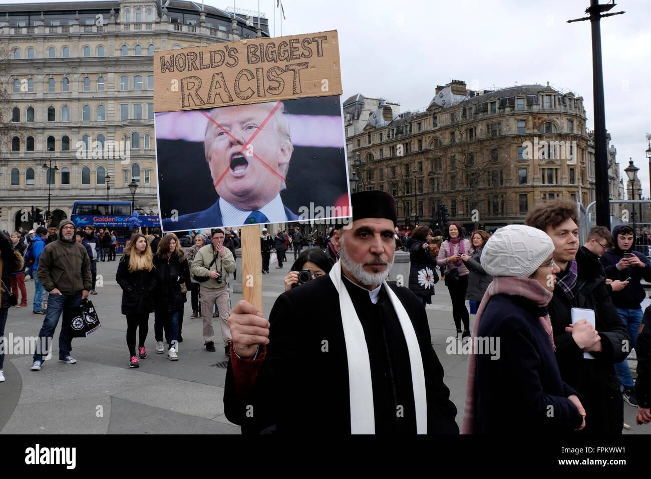 Un uomo musulmano di tenere un cartello con una fotografia del presidente americano Donald Trump, leggere 'più grande del mondo razzista" Foto Stock