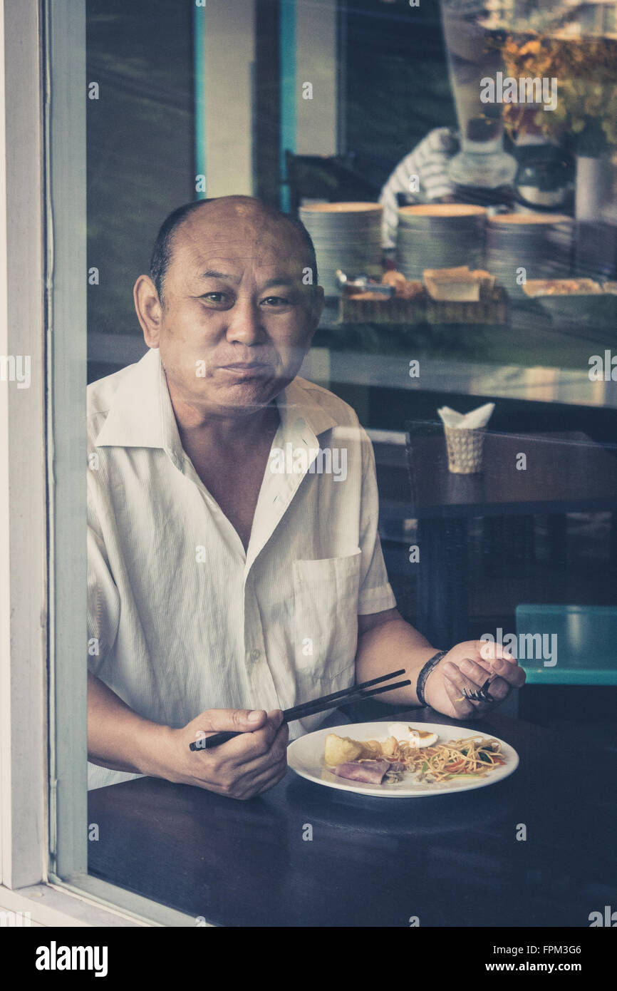 A Saigon, Vietnam - 11 Febbraio 2014: Ritratto di un uomo vecchio con prima colazione in un ristorante. Foto Stock
