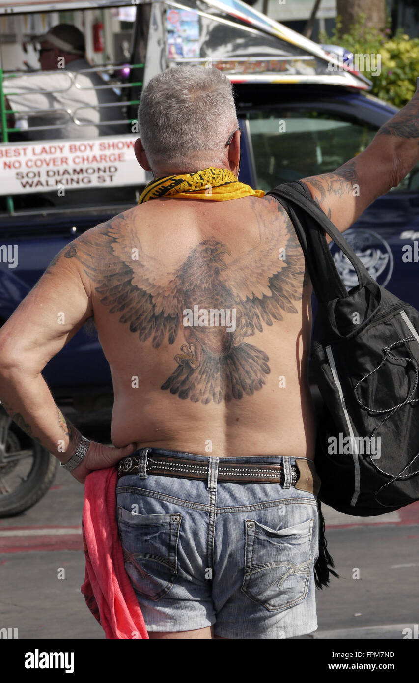 Un singolo tatuato pedonale maschio in attesa di attraversare strada della spiaggia di Pattaya Thailandia Foto Stock