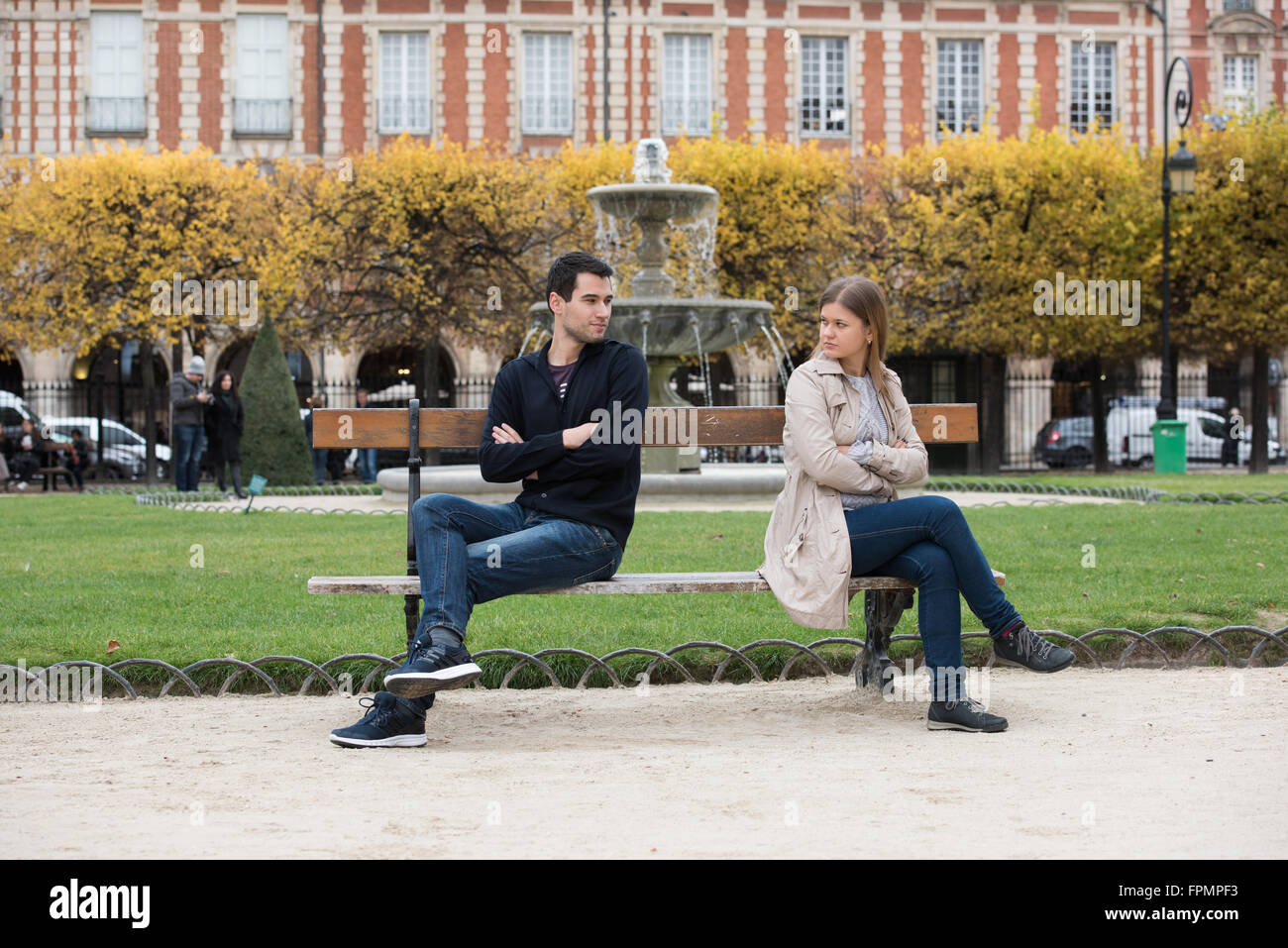 Coppia giovane avente amore lotta sul banco in park a Parigi, Francia Foto Stock