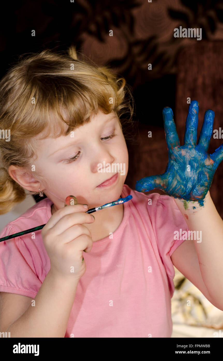 Bambino biondo pittura la sua mano Foto Stock