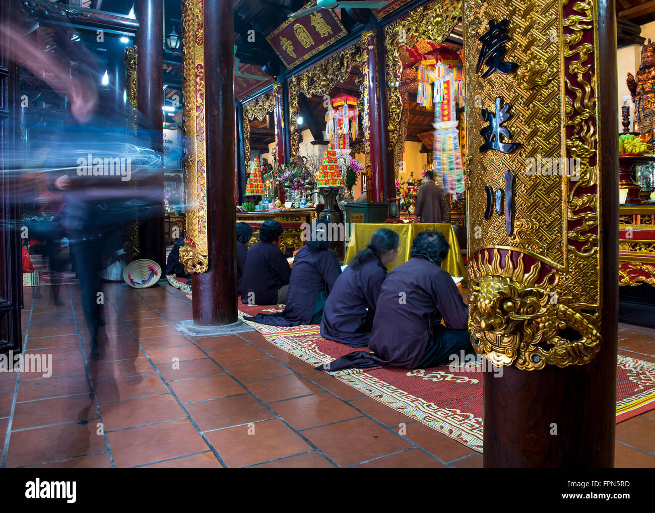 Hanoi, Vietnam. Le donne di pregare all'interno delle antiche Tran Quoc Pagoda buddista di fronte a un santuario ornata Foto Stock