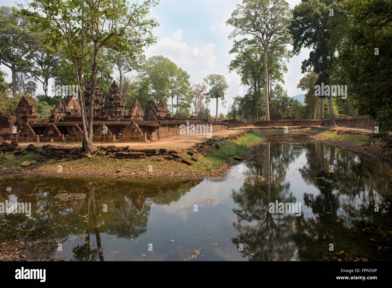 La cittadella delle donne, Banteay Srei, Cambogia, AD 987, vista da attraverso il fossato che mostra alcuni giganteschi alberi della giungla Irvingia mal Foto Stock