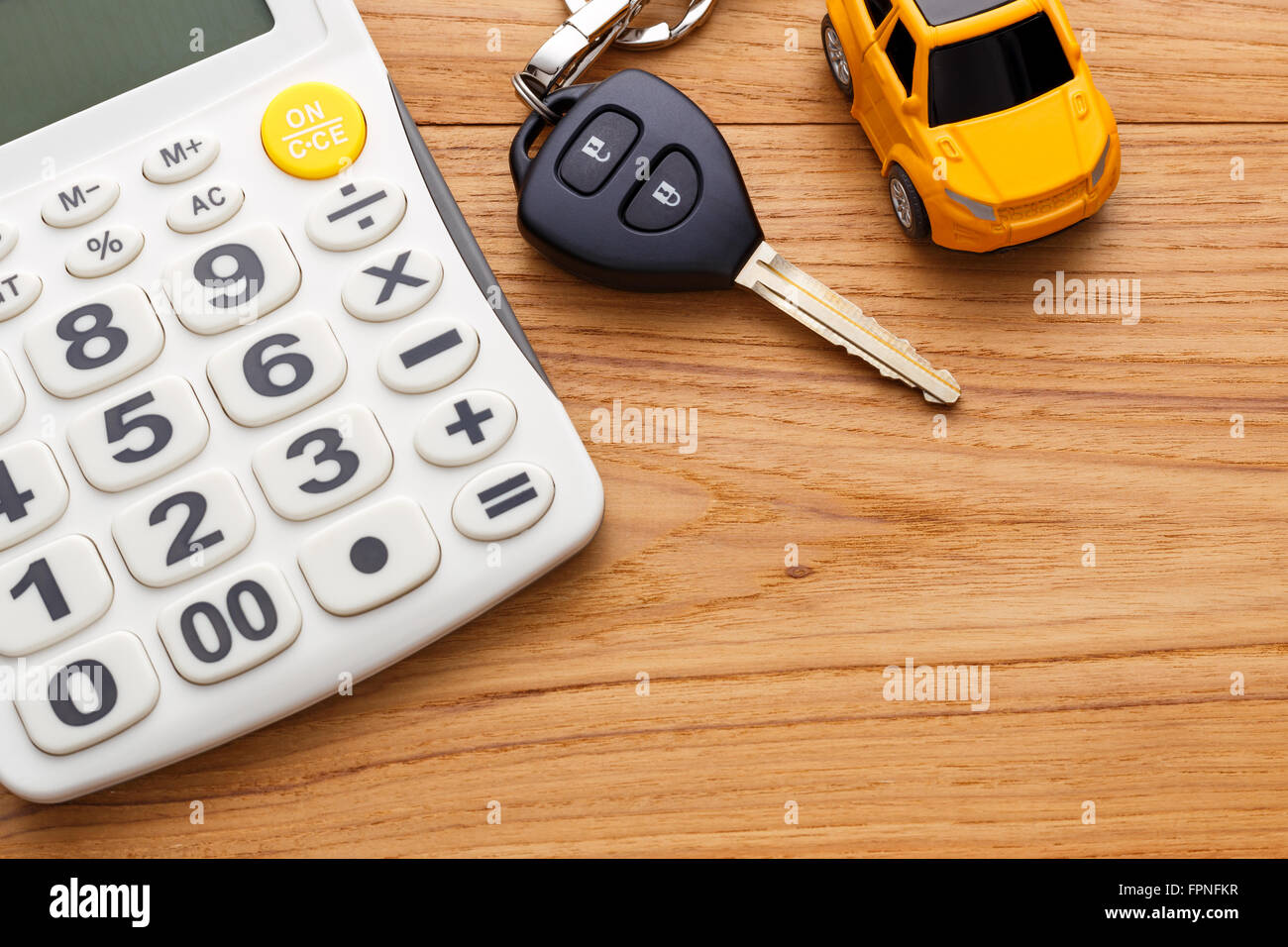 Chiave auto con la calcolatrice sul tavolo di legno Foto Stock