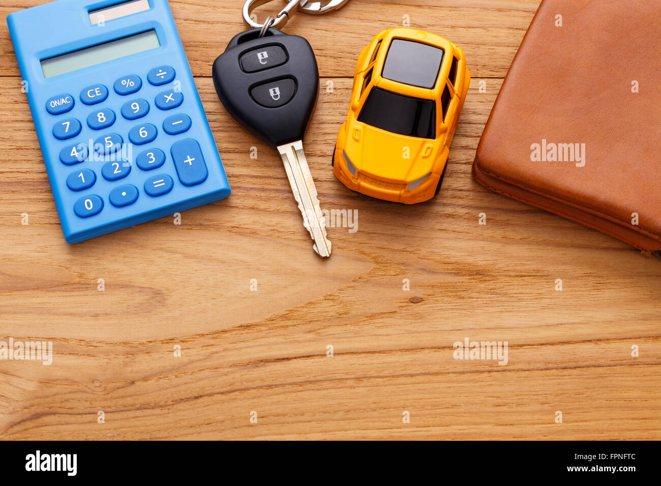 Chiave auto con la calcolatrice su legno sfondo tabella Foto Stock