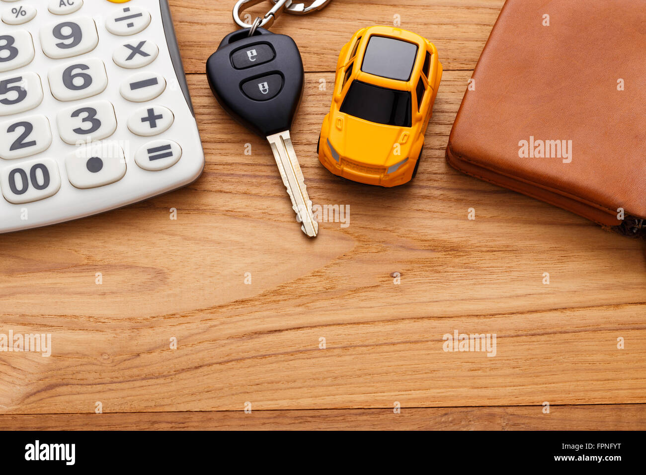 Chiave auto con la calcolatrice e pocket money su legno sfondo tabella Foto Stock