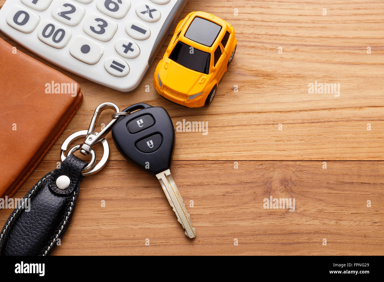 Chiave auto con la calcolatrice e pocket money su legno sfondo tabella Foto Stock