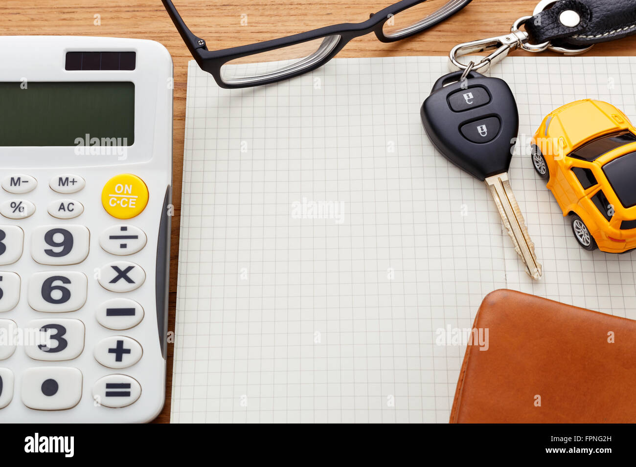 Chiave auto sul notebook vuota con la calcolatrice e pocket money su tavola di legno Foto Stock