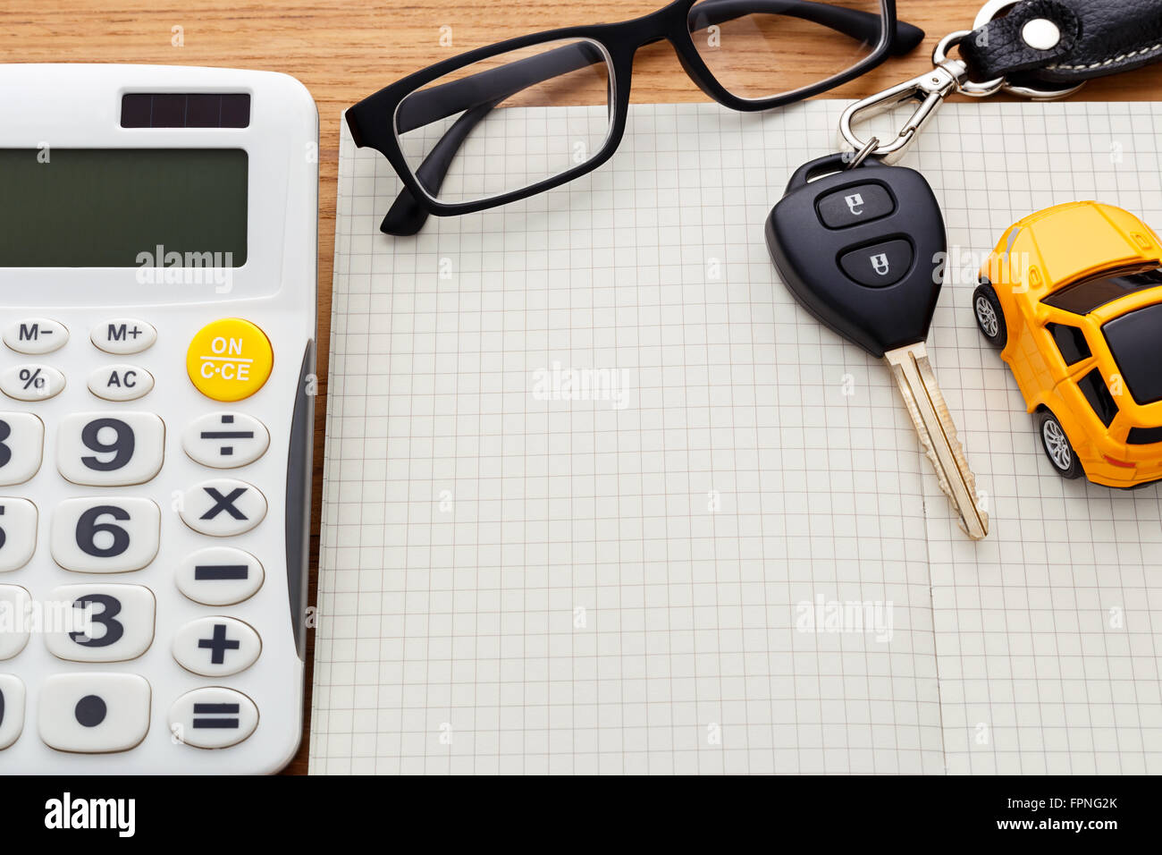 Chiave auto sul notebook vuota con la calcolatrice sul tavolo di legno Foto Stock